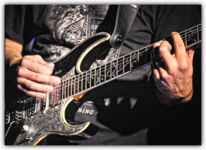 The image shows a close-up of a guitarist with a black electric guitar. When you hover over it, a short description appears: Can - The consolidation and further development of concepts is supported by governance, capability management, and proactive change management.<br />©memephoto