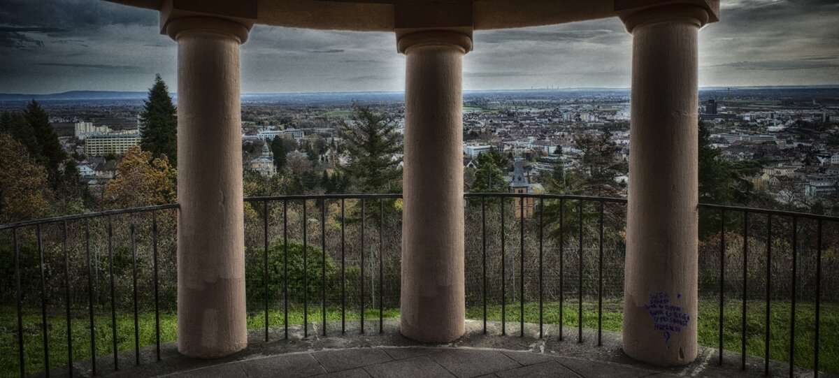 The image shows three pillars overlooking the Rhine Valley. When you hover over the picture, the pillars are replaced by graphic pillars with a description of the self-image (context, actions, skills, beliefs, role, and affiliation), business model (service concept, revenue model, value creation, organization, partners, customers, resources, coordination, and communication), and strategy (vision, mission, critical success factors, value disciplines, SWOT, strategic orientation, strategy goals, and strategic core).<br />©memephoto