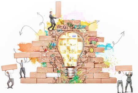Four people are building a wall with graffiti of a light bulb.<br />©alphaspirit, ©memephoto