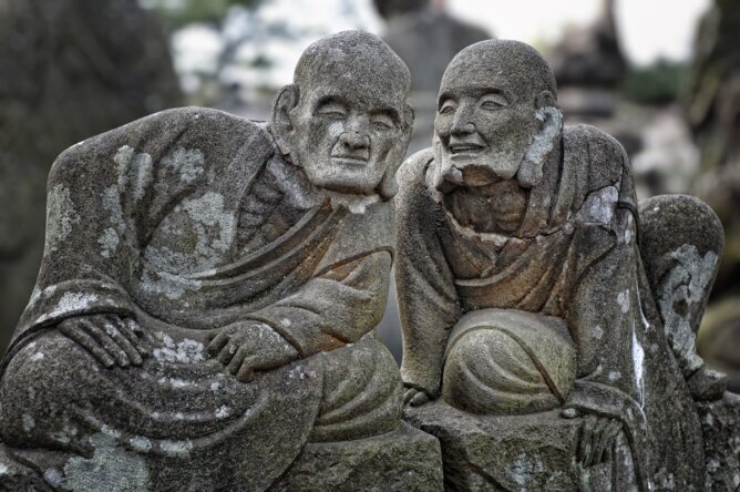 The photo shows two Japanese statues whispering to each other.<br />©memephoto